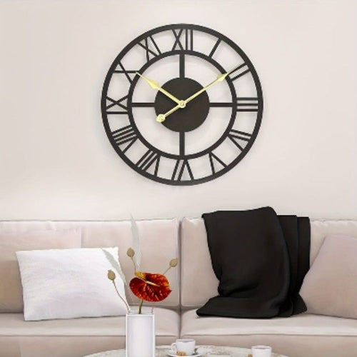 Large wall clock with Roman numerals on a white wall above a beige sofa.